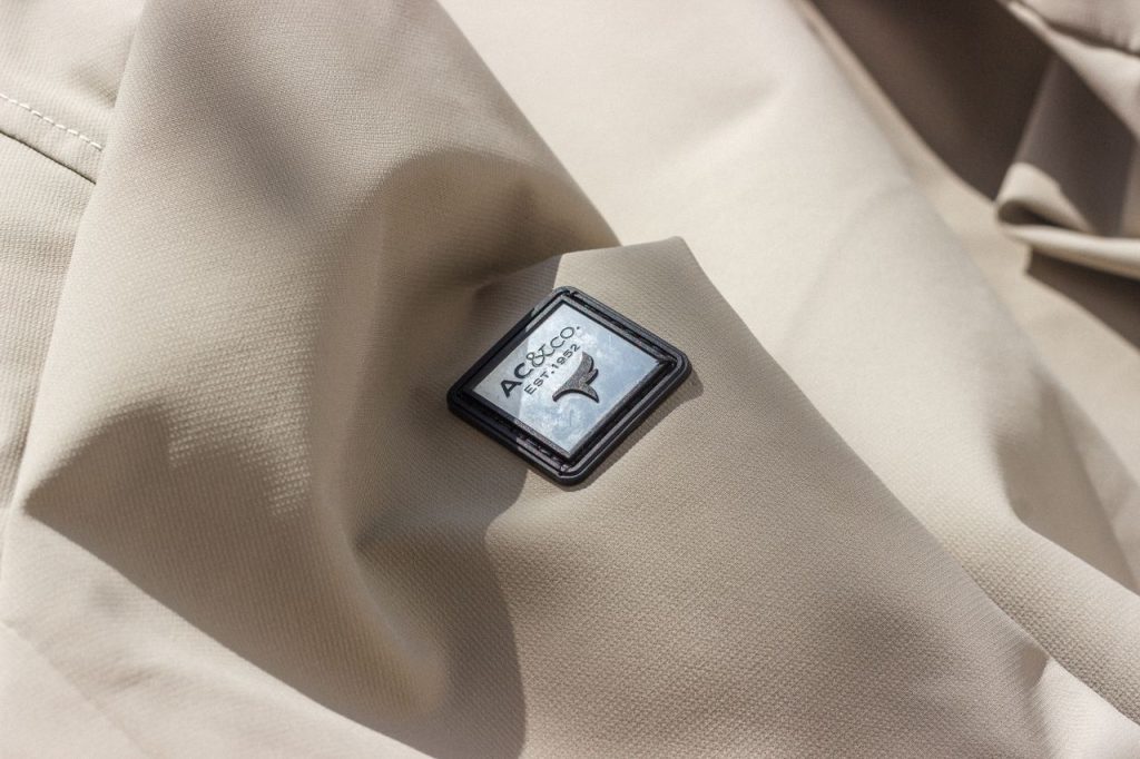 Close-up of beige fabric showcasing AC&Co logo, perfect for fashion content.